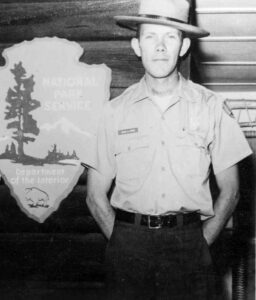 john cook, park ranger in uniform by arrowhead sign