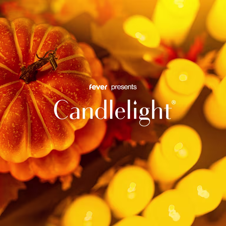 A picture of a pumpkin surrounded by candles.